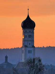'Glühendes Zifferblatt' - der Ursberger Kirchturm während des Sonnenuntergangs.